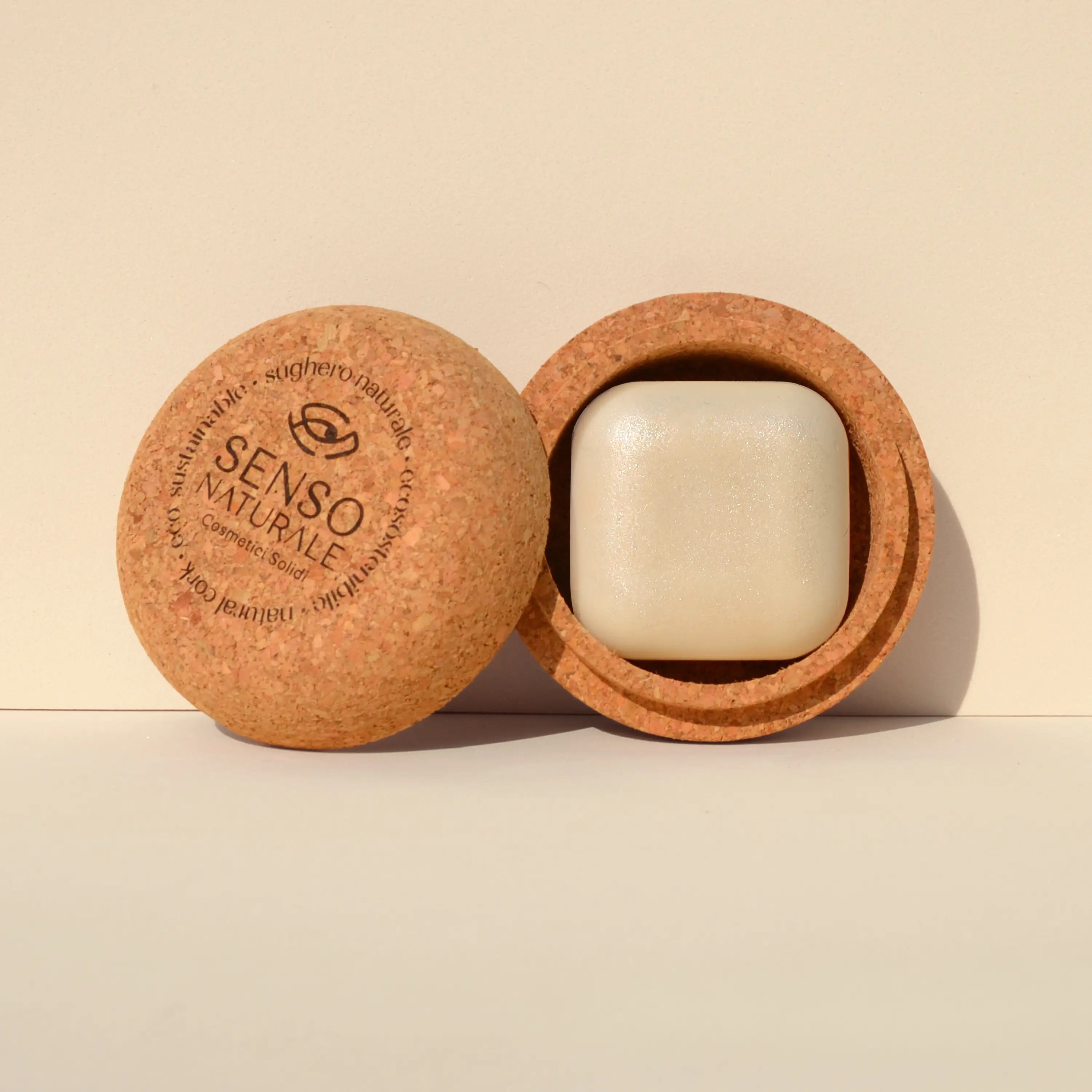 Olio solido corpo Crystal Glow con contenitore in sughero, effetto shimmer dorato e texture vellutata.