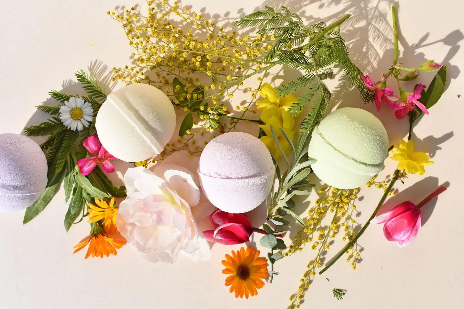 Caramelle da bagno vivaci immerse tra petali e fiori colorati per un bagno gioioso e profumato