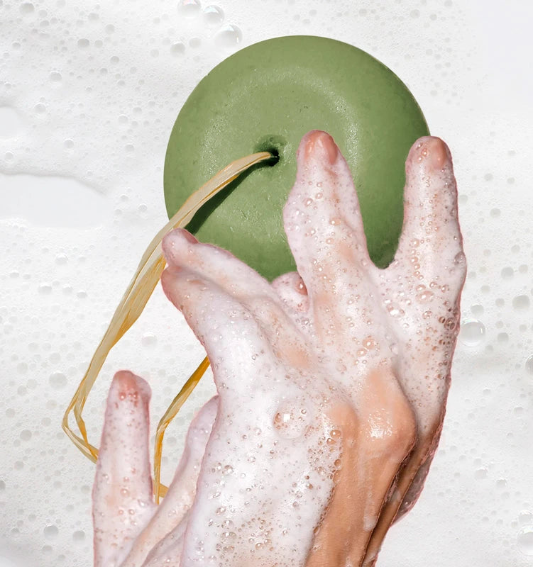 Shampoo solido per capelli ricci e crespi con spirulina, aloe e oli vegetali, su sfondo naturale